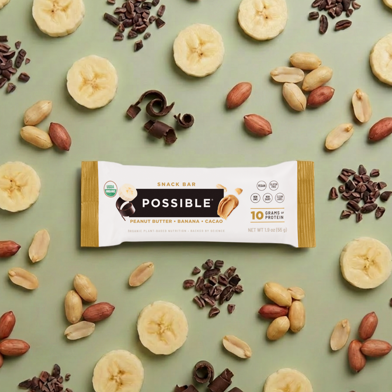 POSSIBLE Peanut Butter Banana Cocoa Snack Bar displayed alongside its key ingredients: Peanuts, bananas, and chocolate nibs, emphasizing whole food nutrition.