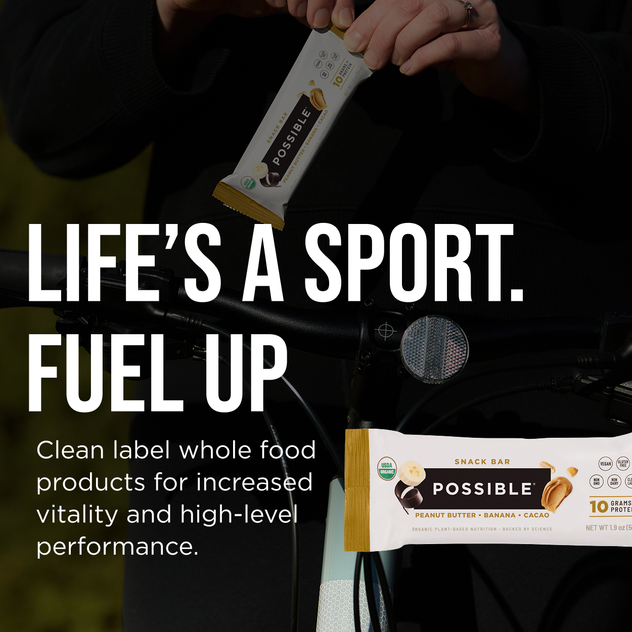 POSSIBLE Peanut Butter Banana Cocoa Snack Bar in hand, ideal for on-the-go snacking, providing 10g of plant-based protein for sustained energy and performance.