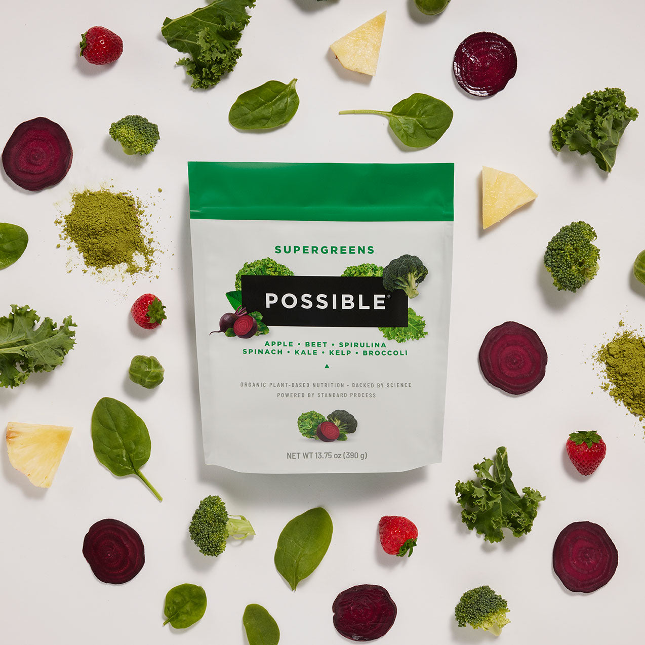 POSSIBLE Supergreens pouch displayed on a flat lay background with scattered superfood ingredients like leafy greens and berries, emphasizing natural nutrition